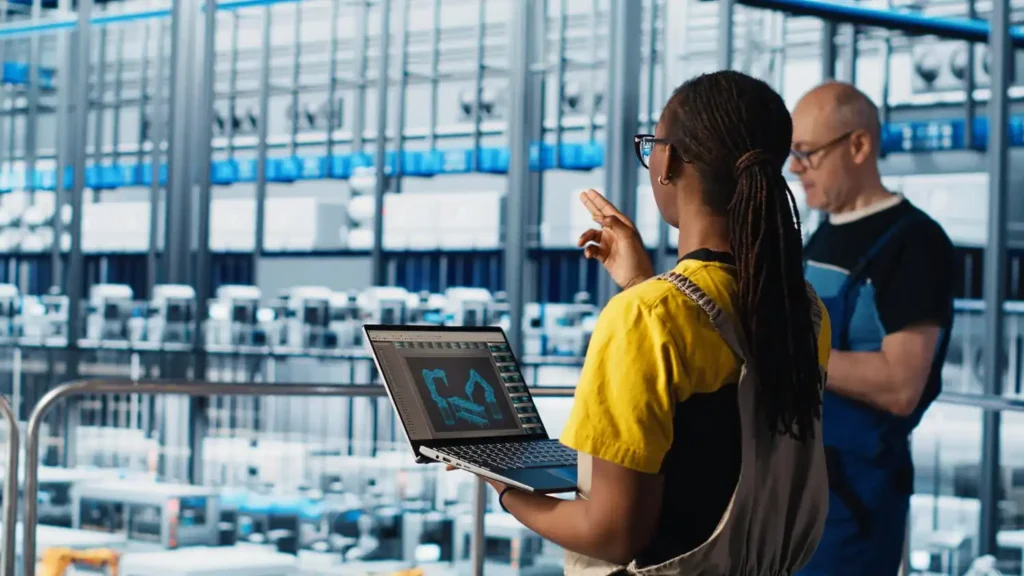 Profissional de tecnologia na indústria 5.0 analisando dados em ambiente de fábrica inteligente, simbolizando o equilíbrio entre automação, sustentabilidade e inteligência humana.